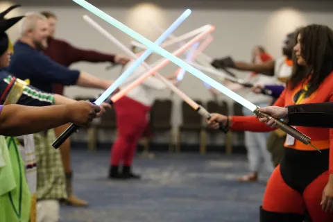 kids dressed in various costumes wielding toy light sabers