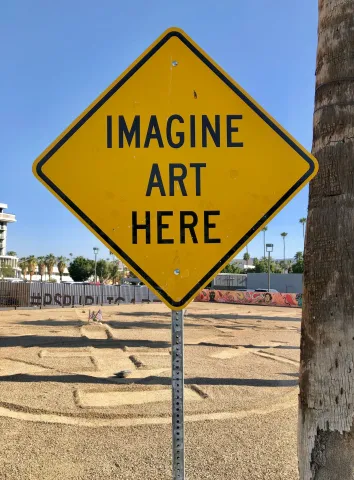 Diamond shaped yellow sign says "Imagine Art Here"