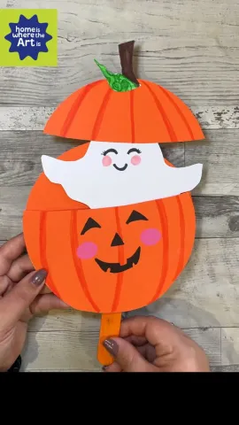 paper jack-o-lantern with ghost popping out the top, held by adult hands
