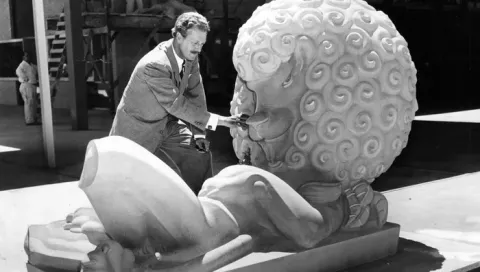 Marshall Fredericks next to sculpture