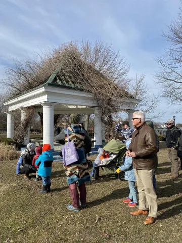 Pavilion in the background with several people standing around bundled up