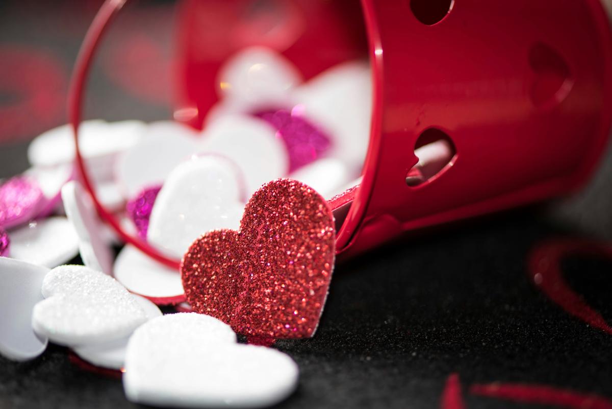 Red bucket spilling sparkly red, white, and pink hearts out of it.